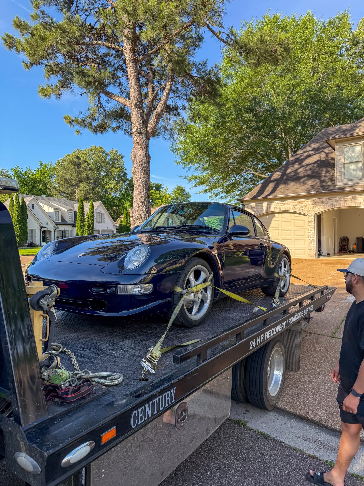 Smiths Towing flatbed with a navy Porsche 911 strapped down in a Cordova, TN driveway