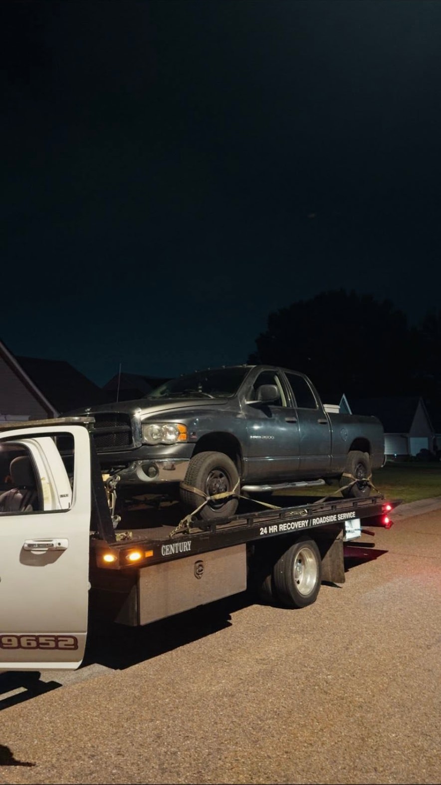 Smiths Towing flatbed transporting a pickup truck during a late-night call near Lakeland, TN